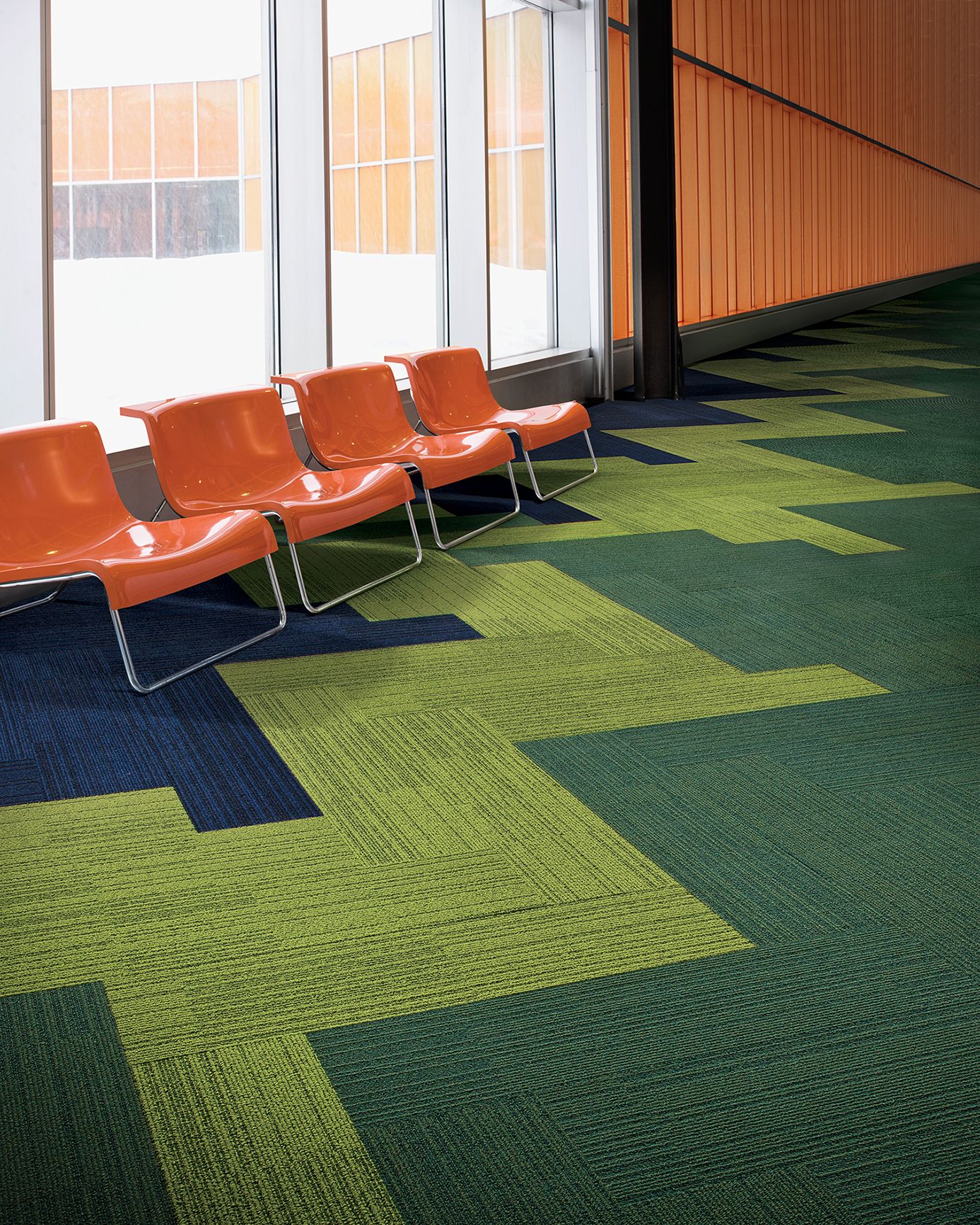 Interface On Line plank carpet tile in waiting area with orange hard plastic chairs against windows image number 8
